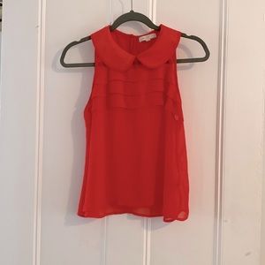 Coral colored chiffon shirt.